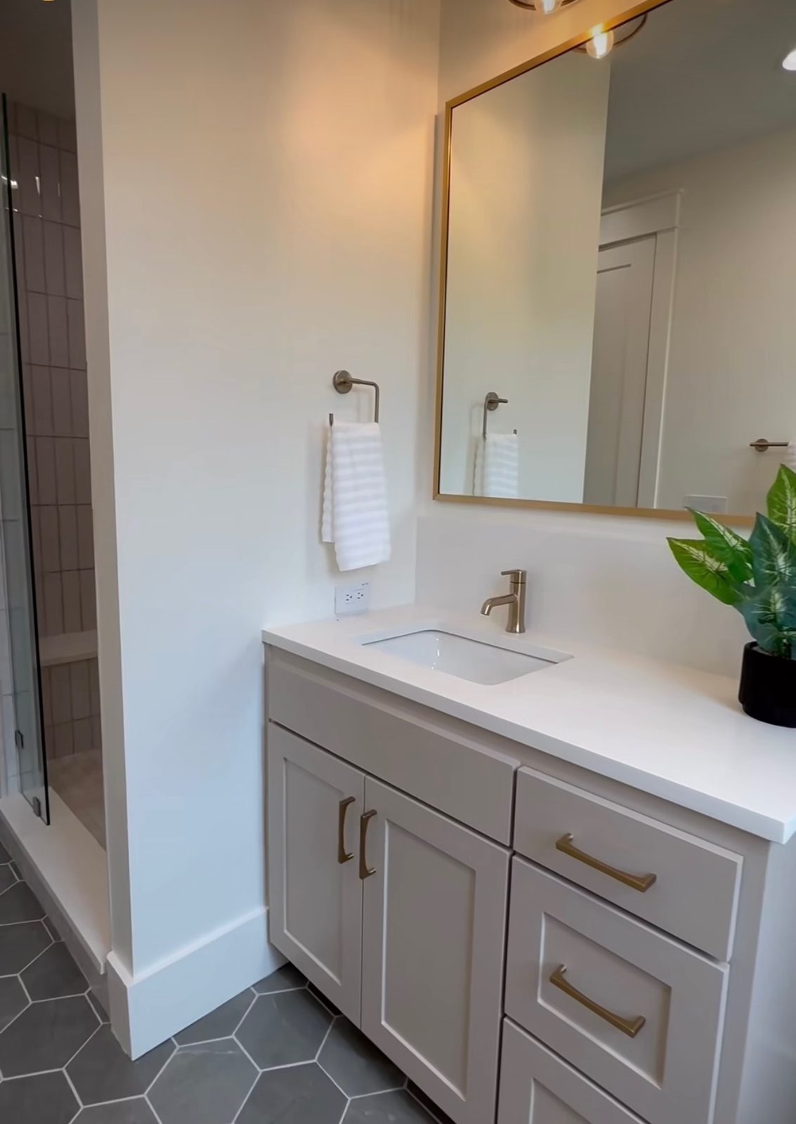 Two-tone vanity with brass hardware and quartz top