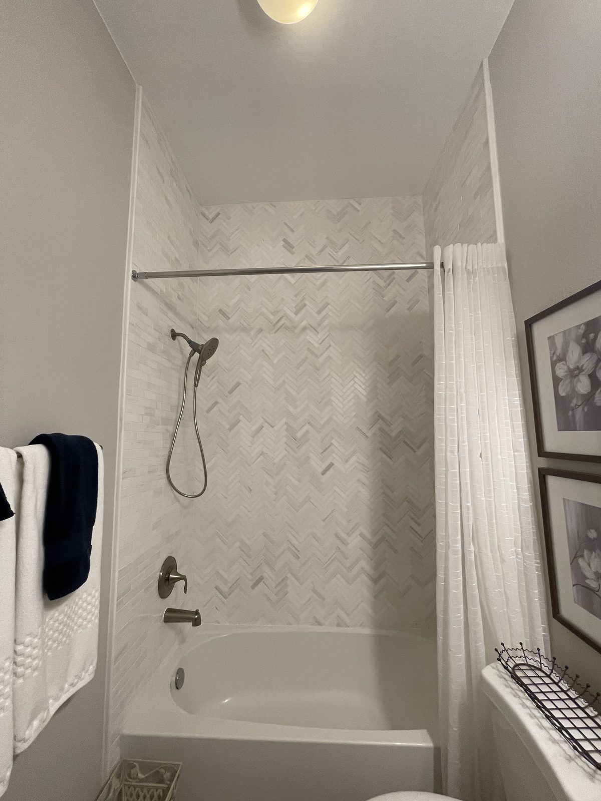 Herringbone tile tub surround with glass shower door