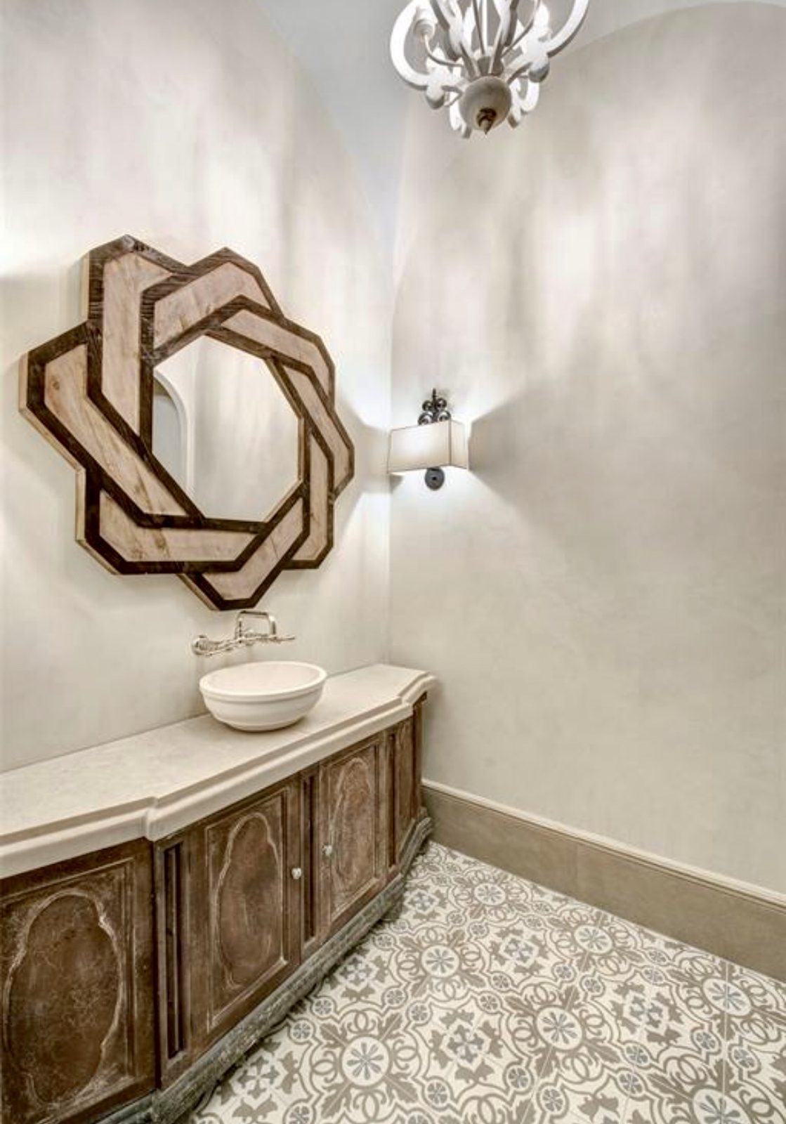 Sculptural wood mirror above a vessel sink vanity